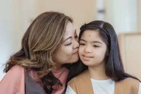 mother kissing daughter